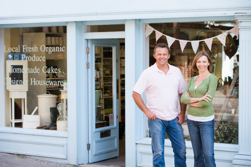 Couple standing in front of organic food store smiling